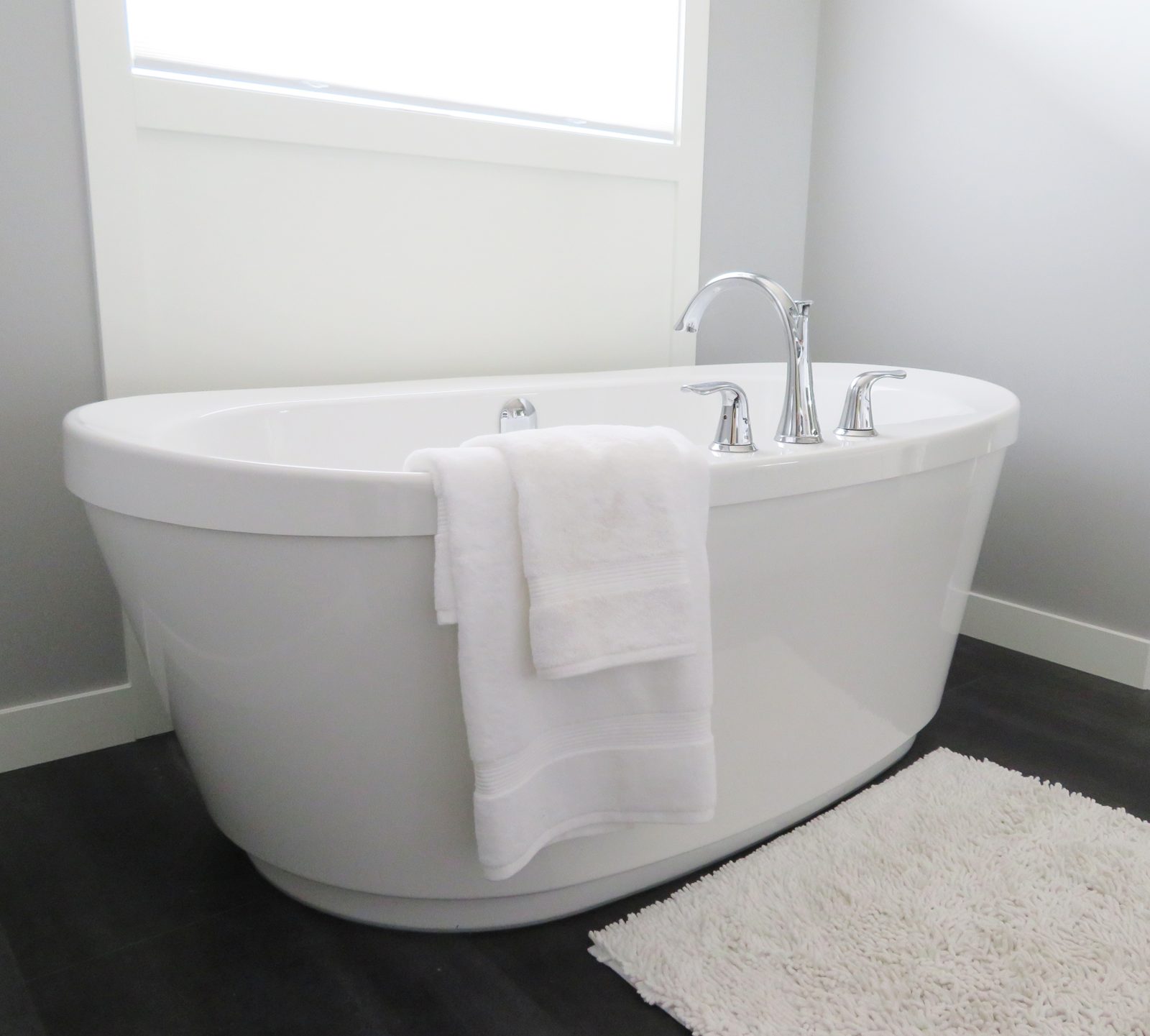 Spotless white bathtub and towels after house cleaning in Brampton
